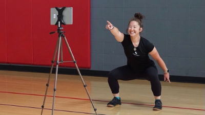 Girl leading a workout in front of an iPad.